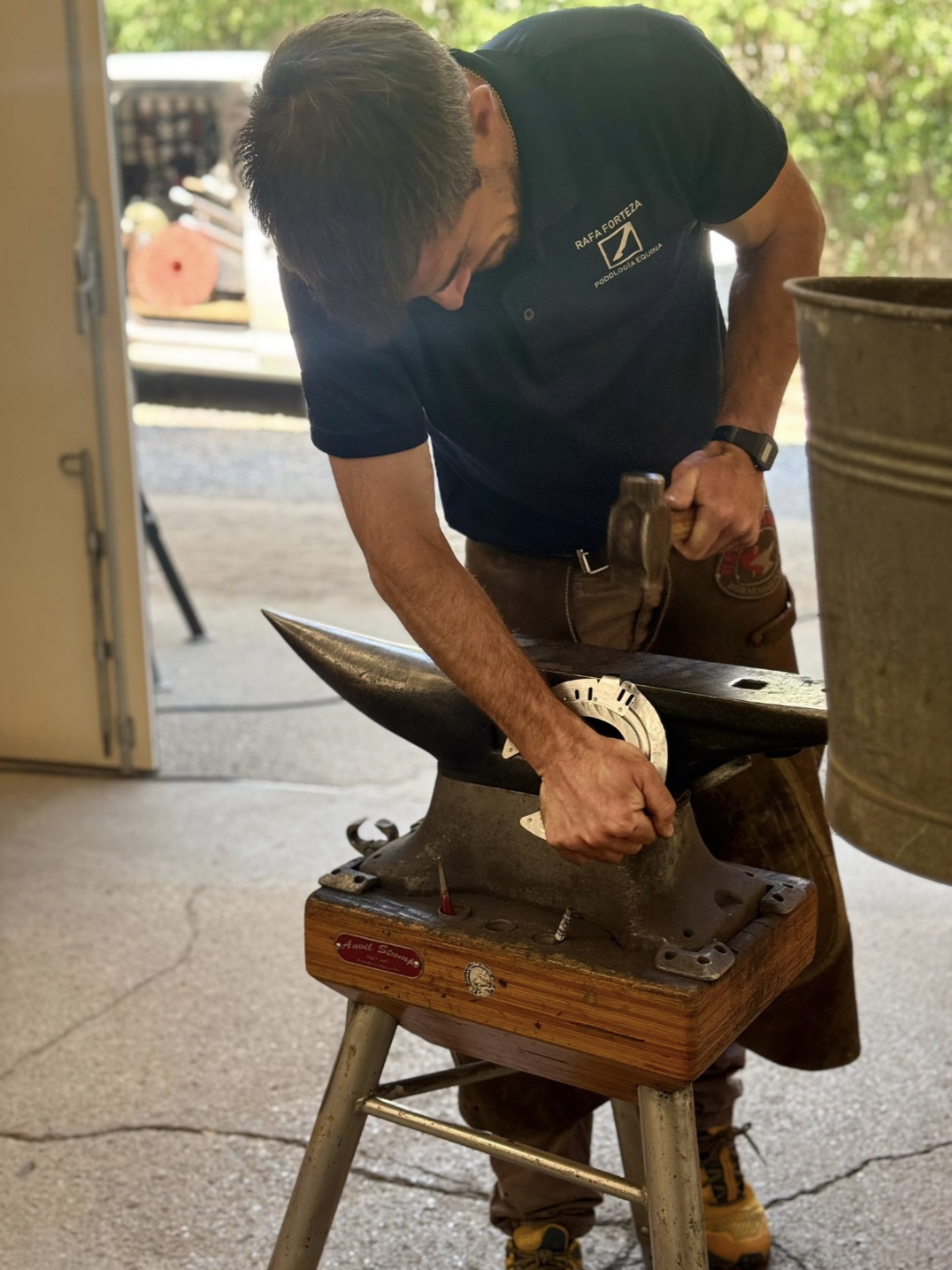 Farrier forging a horseshoe on the anvil